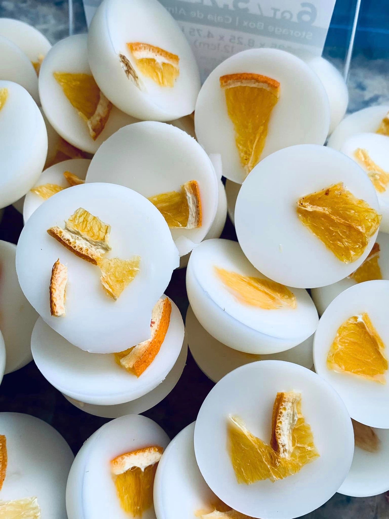 Image of white eco-friendly candles filled with orange bits, crafted for non-toxic and soothing aromatherapy experiences in any setting.